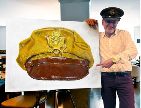 Laurence Kirwan pointing to a military cap painting
