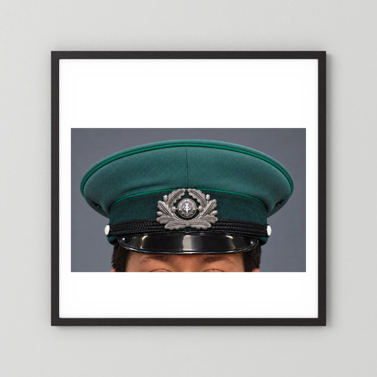 East German Volkpolizei (People's Police), Visor Cap, January 1989 — photograph displayed in a black wood frame mockup
