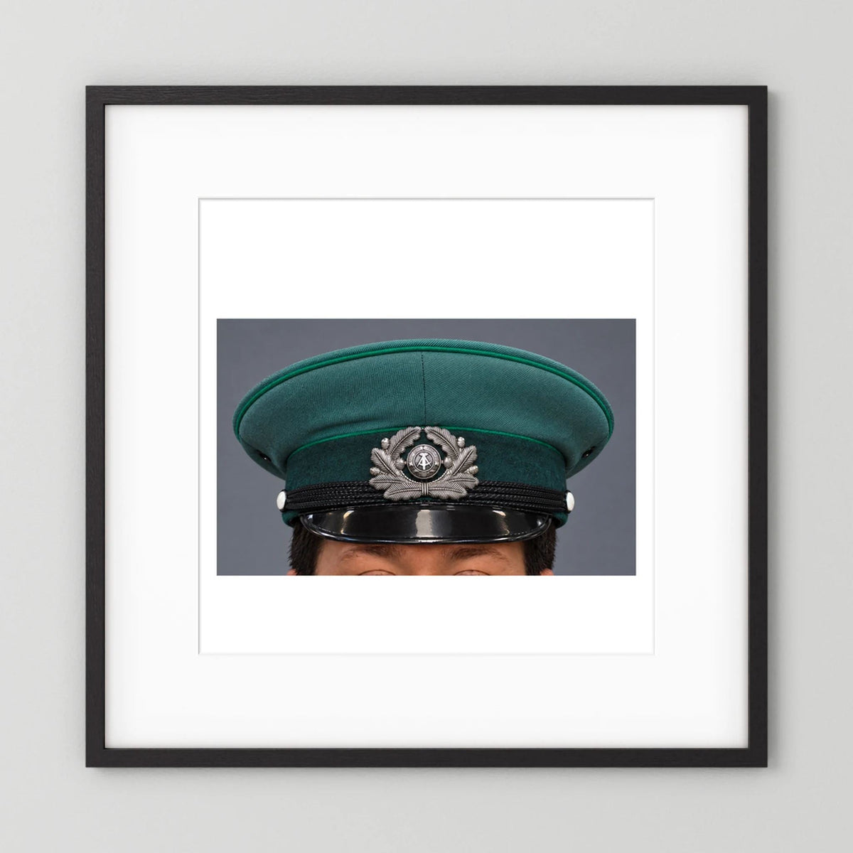 East German Volkpolizei (People's Police), Visor Cap, January 1989 — photograph displayed in a black wood frame mockup