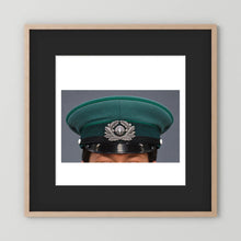 East German Volkpolizei (People's Police), Visor Cap, January 1989 — photograph displayed in a natural oak frame mockup