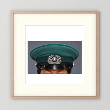 East German Volkpolizei (People's Police), Visor Cap, January 1989 — photograph displayed in a natural oak frame mockup