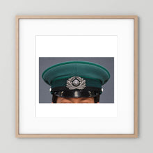 East German Volkpolizei (People's Police), Visor Cap, January 1989 — photograph displayed in a natural oak frame mockup