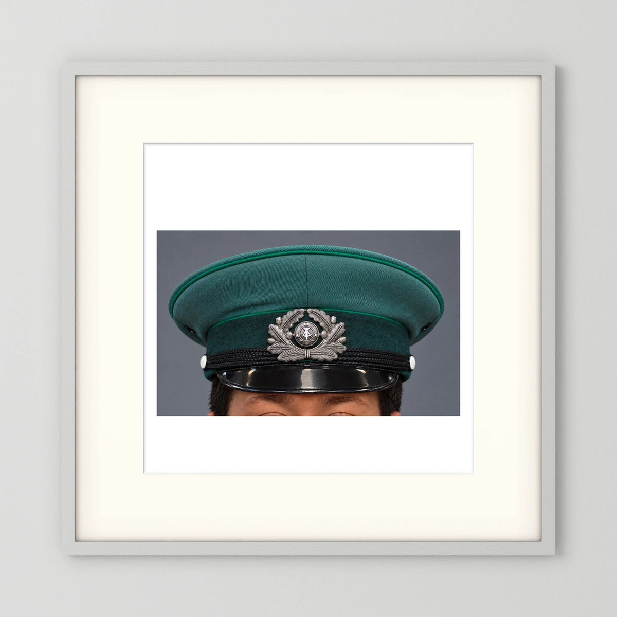 East German Volkpolizei (People's Police), Visor Cap, January 1989 — photograph displayed in a white wood frame mockup