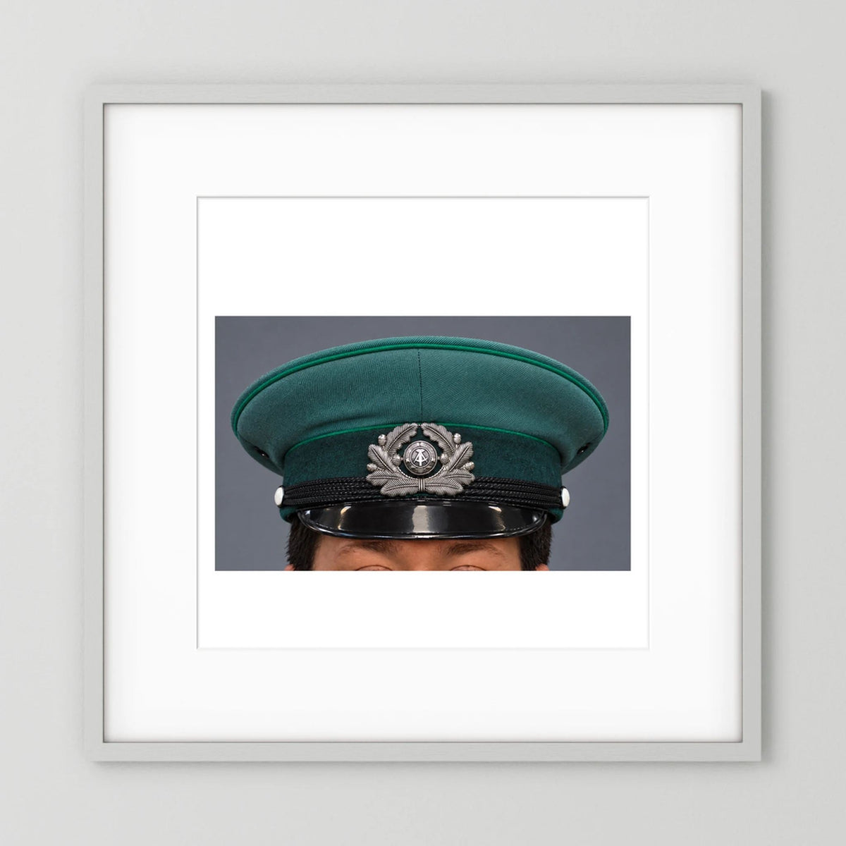 East German Volkpolizei (People's Police), Visor Cap, January 1989 — photograph displayed in a white wood frame mockup