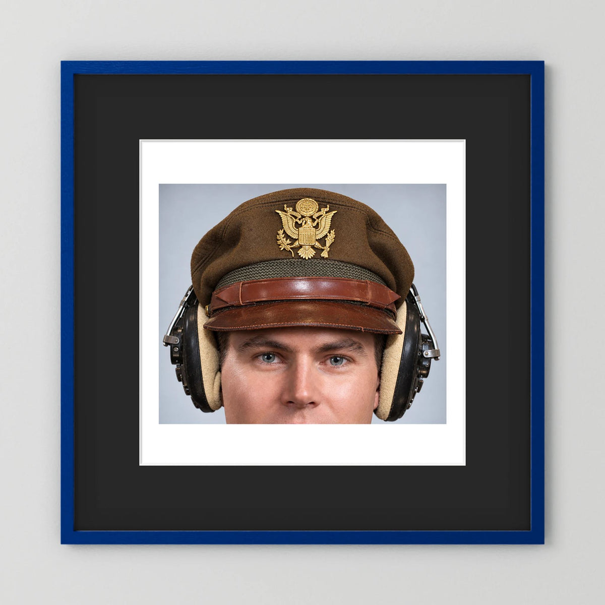 US Army Air Force WW2 Crusher Caps with headphones. Temperate Cover — photograph displayed in a black wood frame mockup