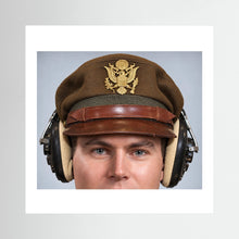 US Army Air Force WW2 Crusher Caps with headphones. Temperate Cover — photograph displayed in a black wood frame mockup